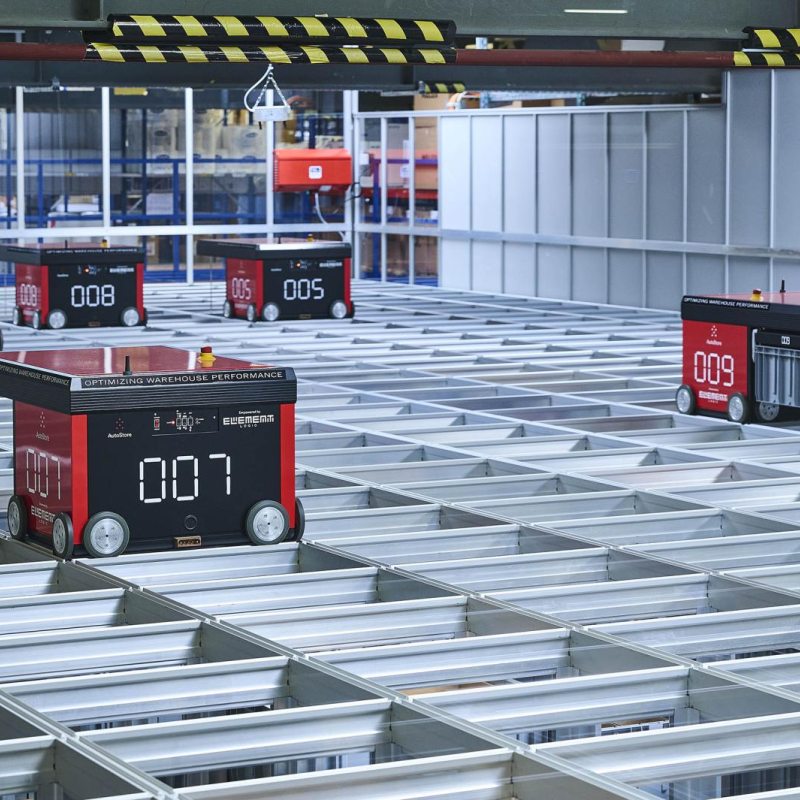 Zehn Robots bewegen sich auf der Oberseite des Grids, heben die Behälter mit den Waren an, übergeben sie an die Arbeitsplätze und stapeln sie nach der Kommissionierung wieder ein.
